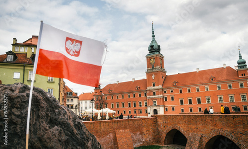 Old town in Warsaw. Polish flag in front of The Royal castle.