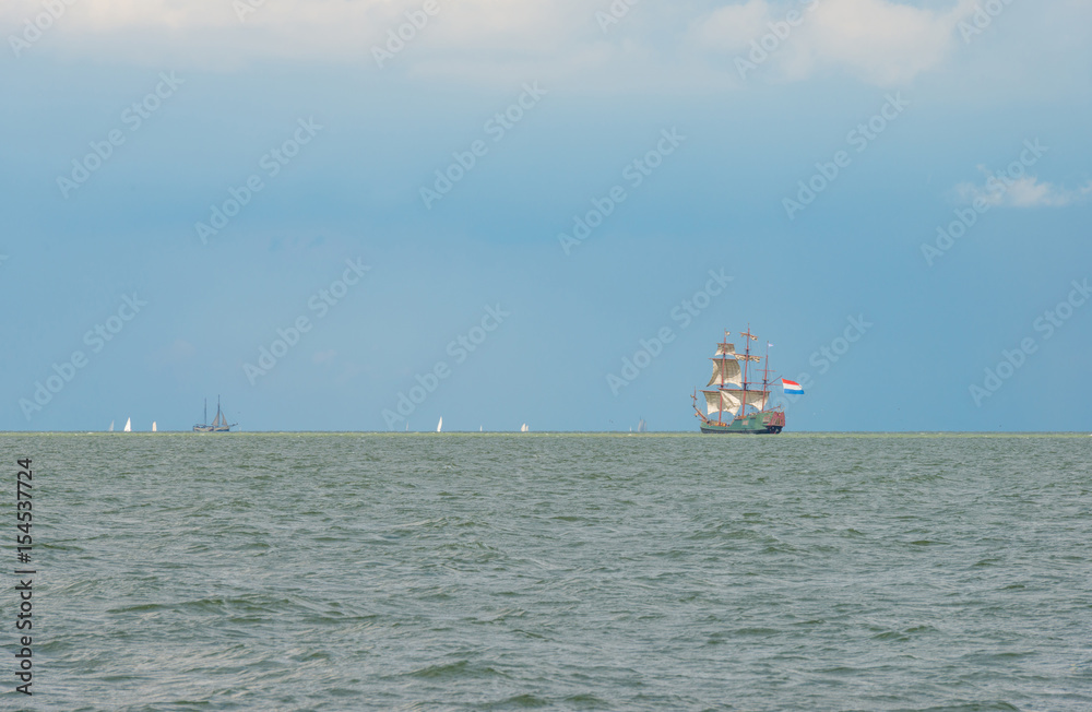 Sailboat sailing in a lake below a cloudy sky
