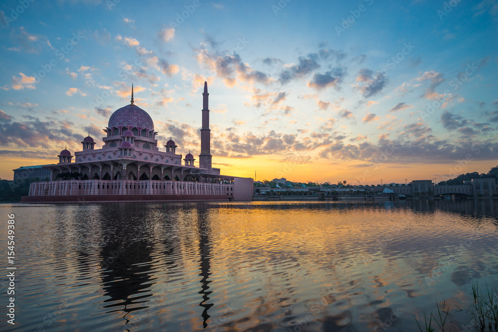 PUTRAJAYA, MALAYSIA - 9TH APRIL 2017; Sunrise moment at Putra Mosque, a principal mosque of Putrajaya, Malaysia. Construction of the mosque began in 1997 and was completed two years later.