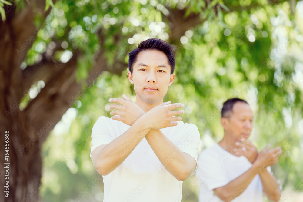 People practicing thai chi in park People practicing thai chi in park