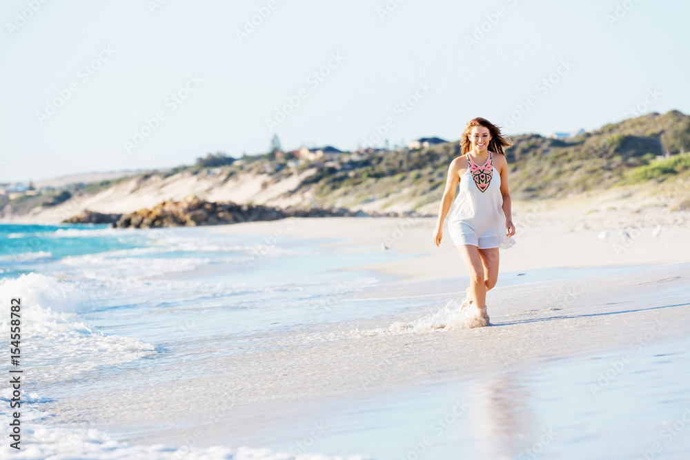 Young woman walking along the beach