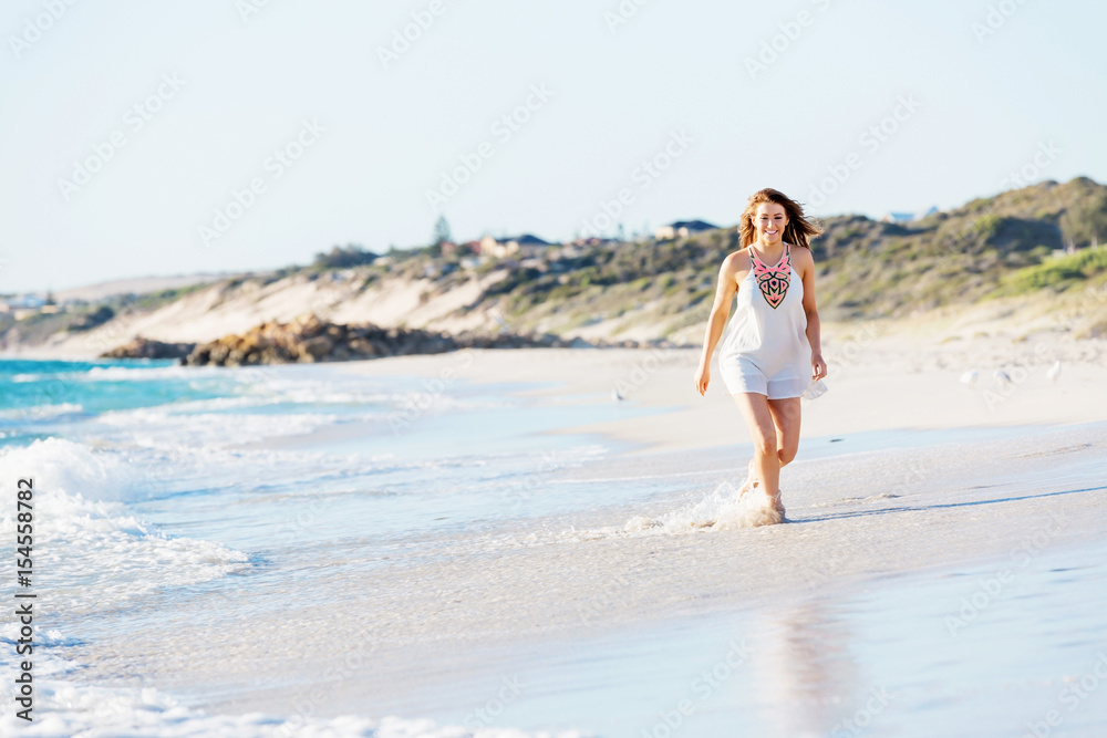 Young woman walking along the beach Young woman walking along the beach