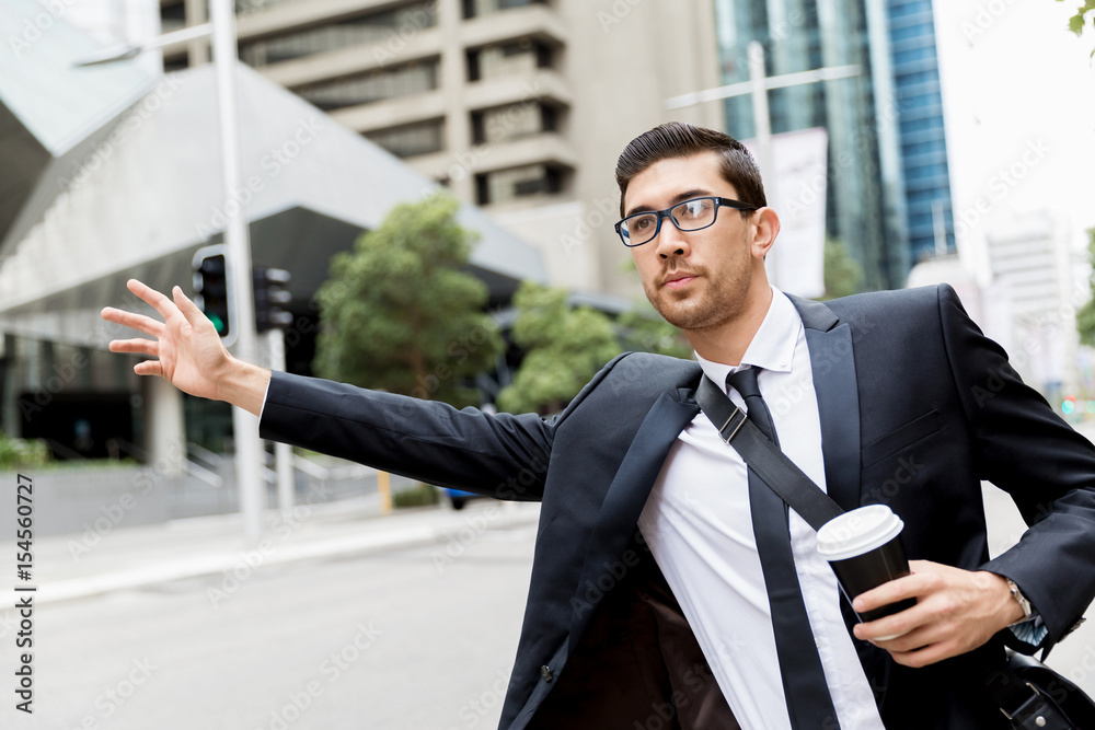 Young businessman hailing for a taxi Young businessman hailing for a taxi