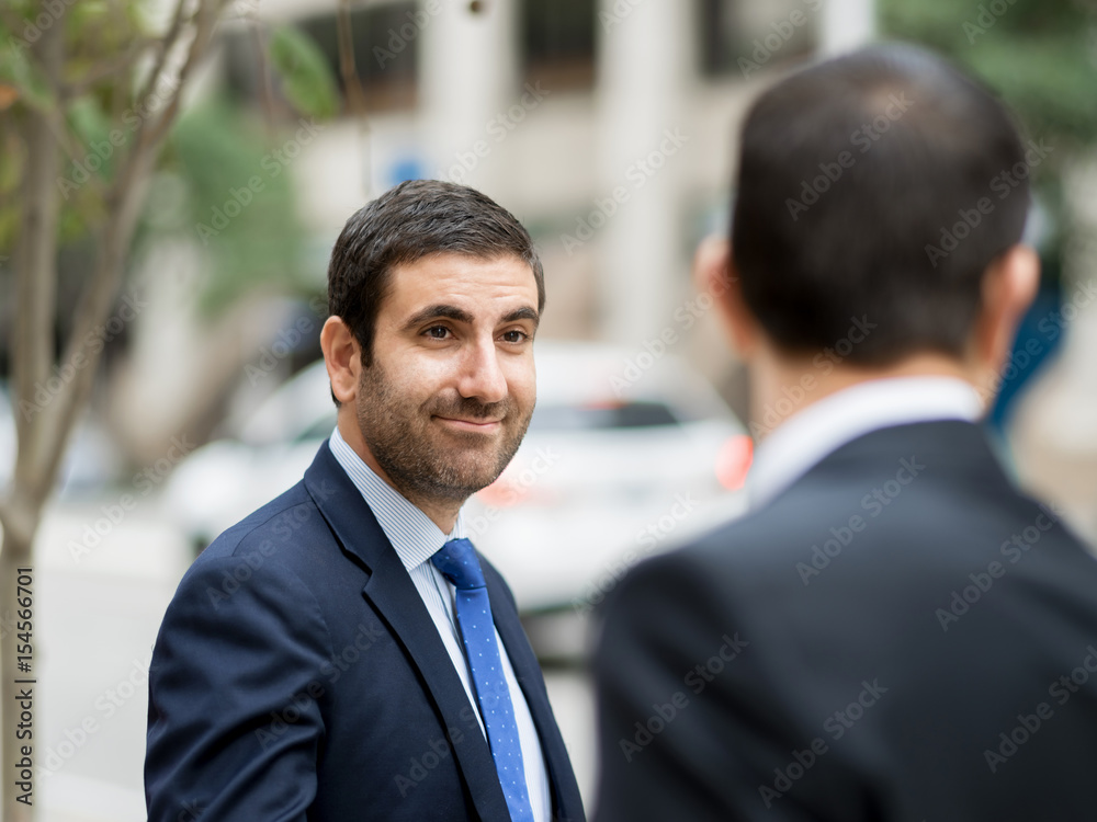 Two businessmen talking outdoors