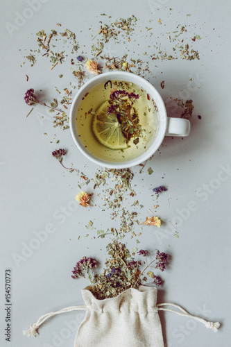 Tea time. Dry herbal tea and cup of hot tea on the gray background