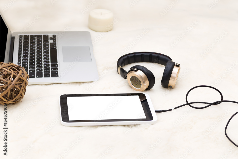 Tablet with headphones on a blanket, top view Tablet with headphones on a blanket, top view