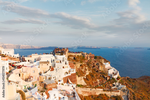 lanscape of Oia with people watching sunset, volcano caldera and Aegan sea, beautiful details of Santorini island, Greece