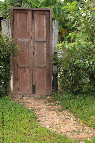 Stone pathway leading to wooden door in garden.