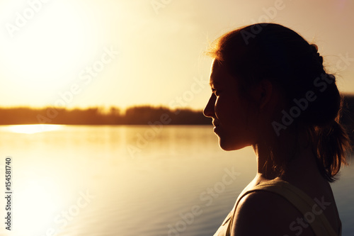 Young woman looking into the distance at sunset