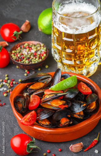 Mussels in shells with tomatoes and spicy sauce of chili peppers and garlic. Tasty snack to beer. Mediterranean dishes. Selective focus