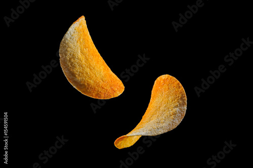 Falling potato chips isolated on black background