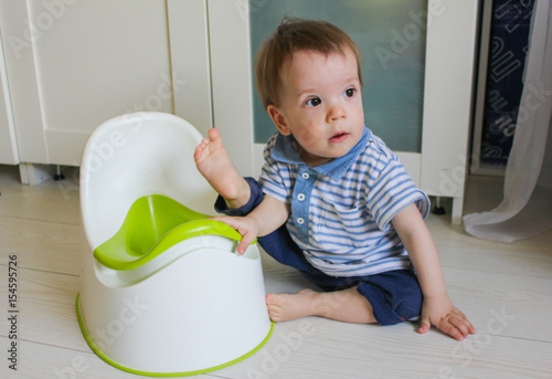 A little boy learns to go potty. Accustom the child to the potty..