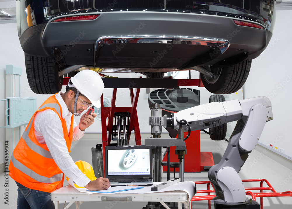 Fototapeta premium Mechanic with assistance robotic inspection wheel balancing of modern car in automotive industry 4.0 concept