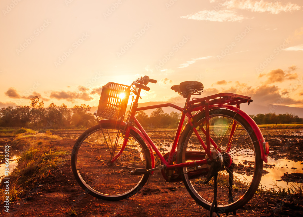 Beautiful landscape at sunset time with red classic bicycle