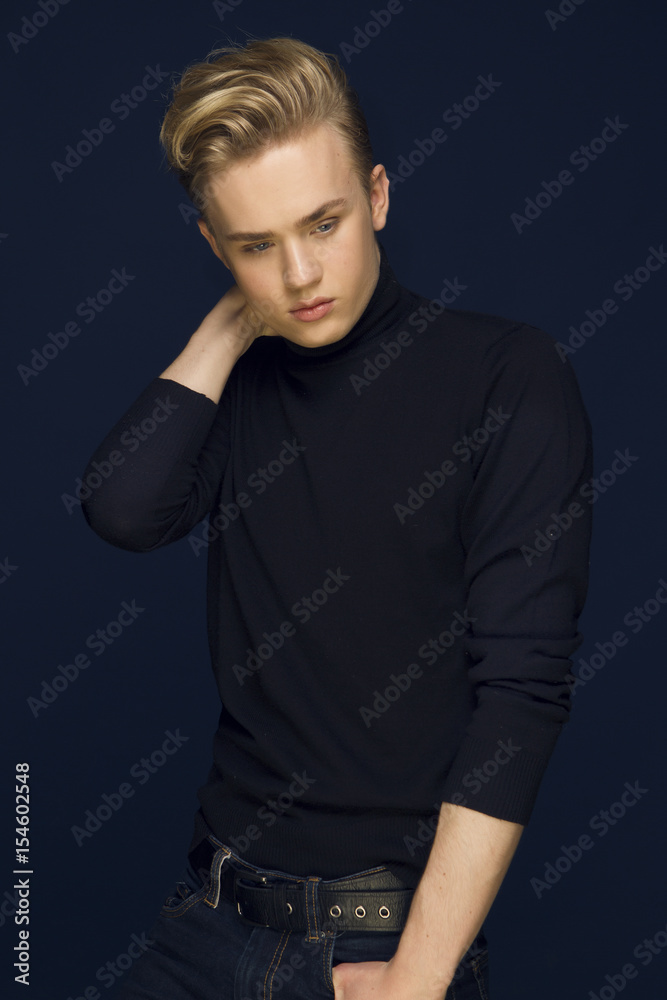 Attractive young guy posing in studio, blond hair