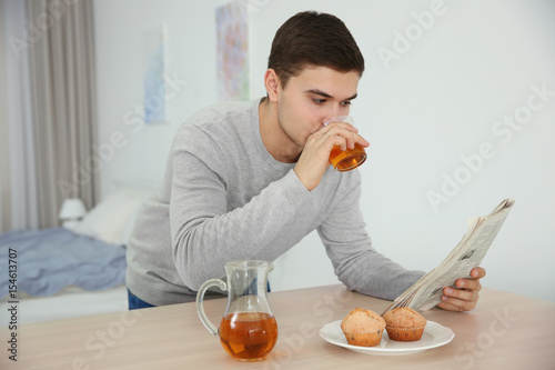 Young man drinking juice at...