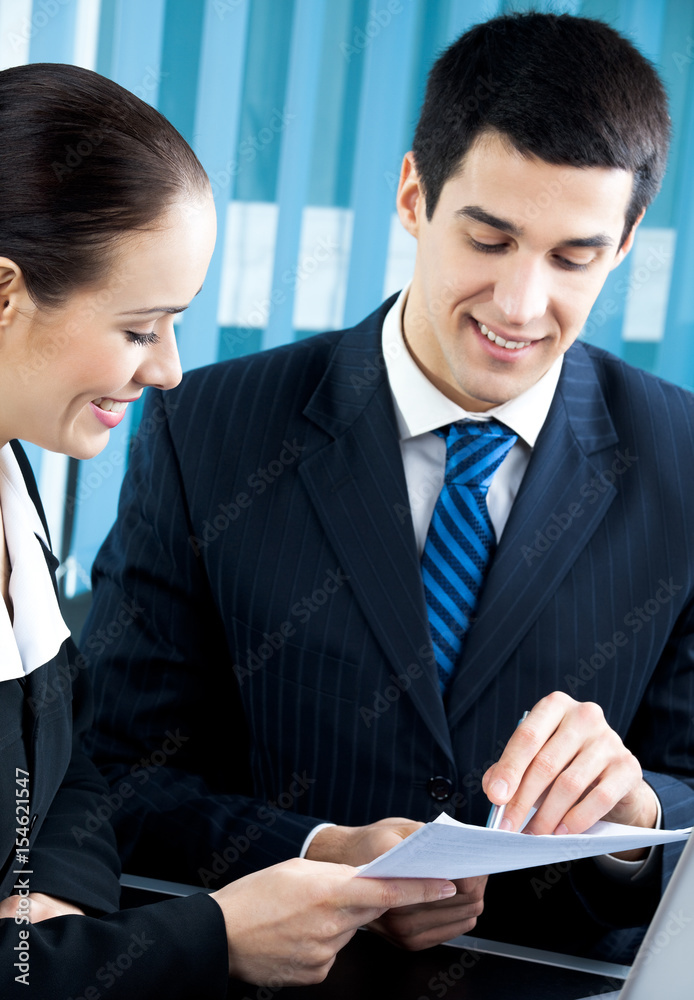 Two happy businesspeople working together at office Two happy businesspeople working together at office
