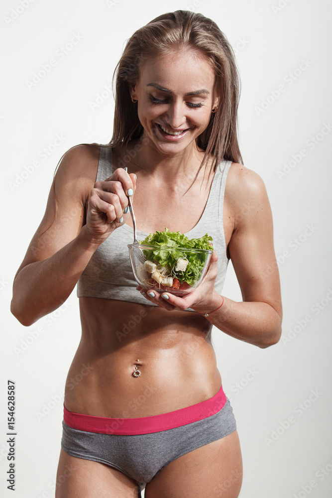 Young sportswoman eating fresh healthy salad Young sportswoman eating fresh healthy salad
