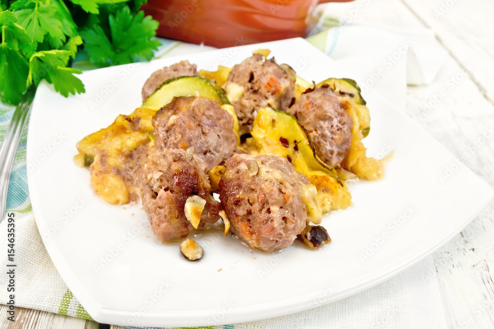 Meatballs with zucchini and nuts in plate on board