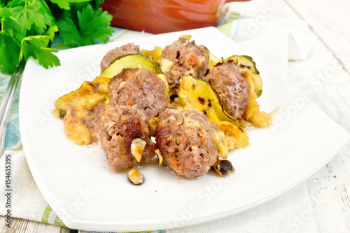 Meatballs with zucchini and nuts in plate on board