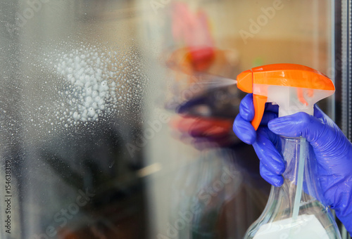Woman cleaning a window with cleaning sprayer