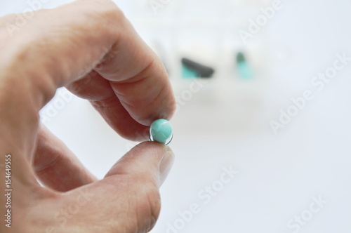 medicine capsule picking in human finger with drug box background