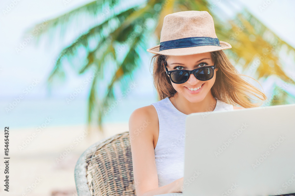 Young woman working in laptop on the beach. Freelance work