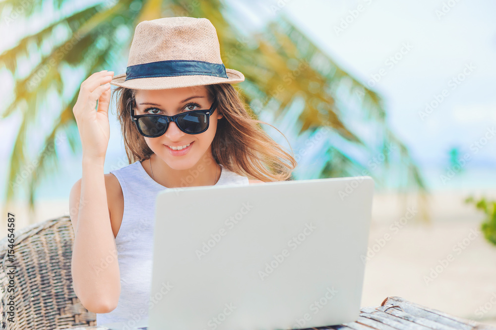 Young woman working in laptop on the beach. Freelance work