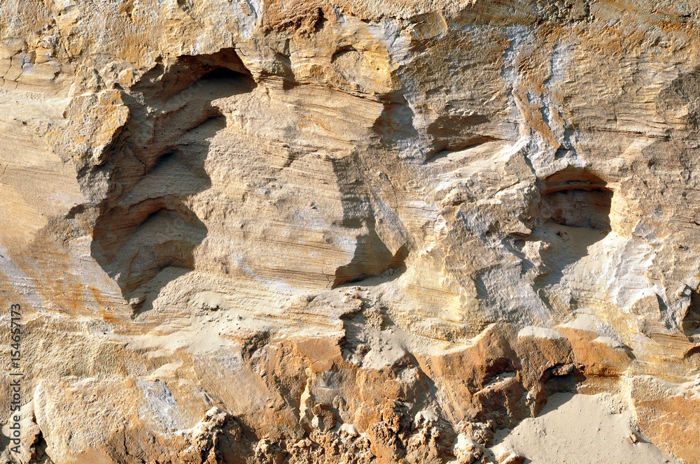 The texture of the rock of yellow sandstone, desert. Curves abstract shapes with shadows.