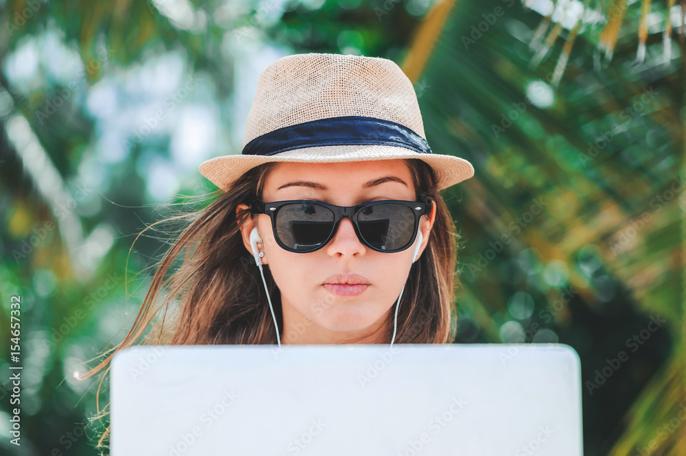Young woman freelancer working in laptop on the beach. Freelance work