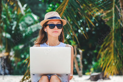 Obraz na płótnie Young woman freelancer working in laptop on the beach. Freelance work w salonie