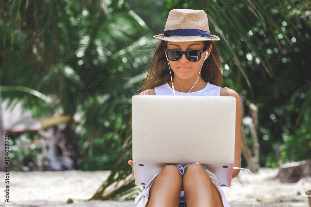 Young woman freelancer working in laptop on the beach. Freelance work