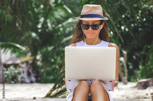 Obraz na płótnie Young woman freelancer working in laptop on the beach. Freelance work w salonie