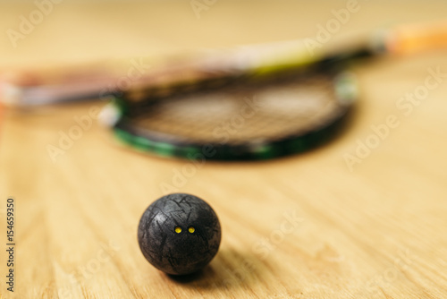Squash game concept, racket and ball closeup view