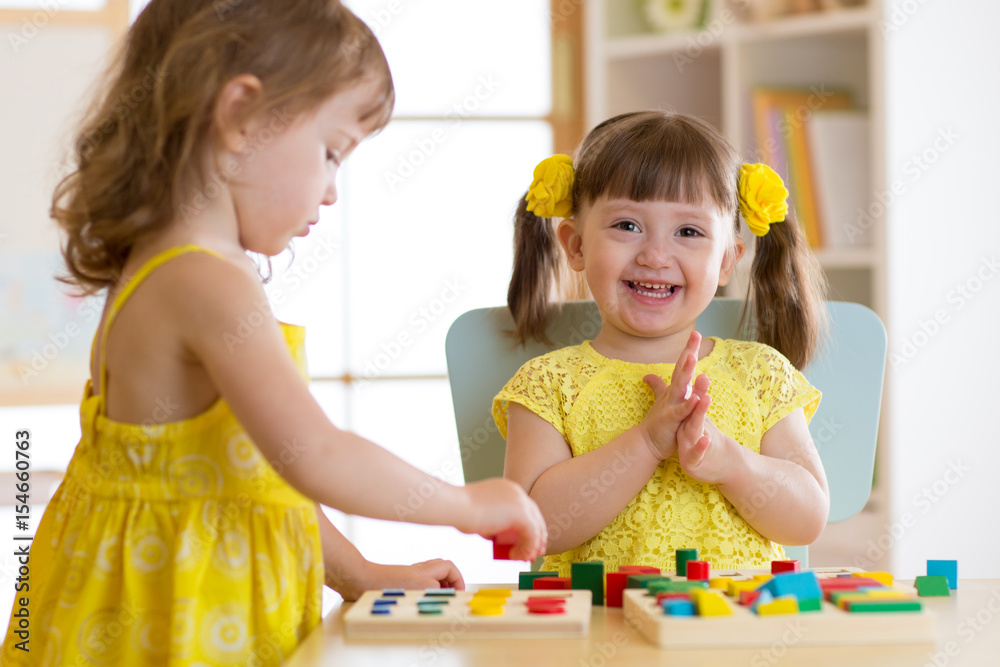 Fototapeta premium Children kids play with educational toys, arranging and sorting colors and shapes. Learning via experience conception.