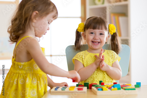Children kids play with educational toys  arranging and sorting colors and shapes. Learning via experience conception.