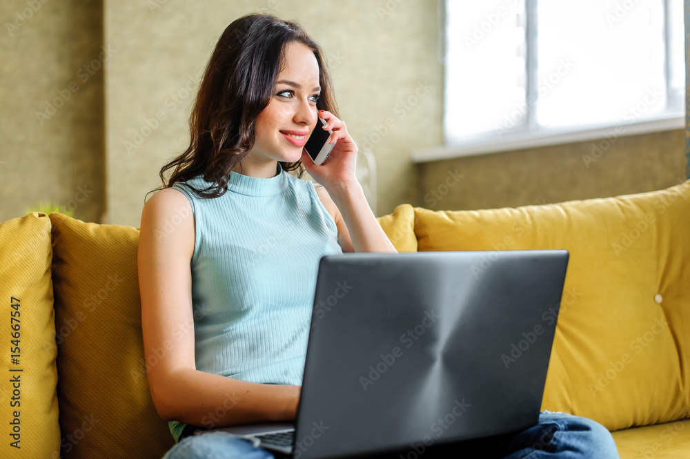 Beautiful woman sitting on sofa at home with laptop Beautiful woman sitting on sofa at home with laptop