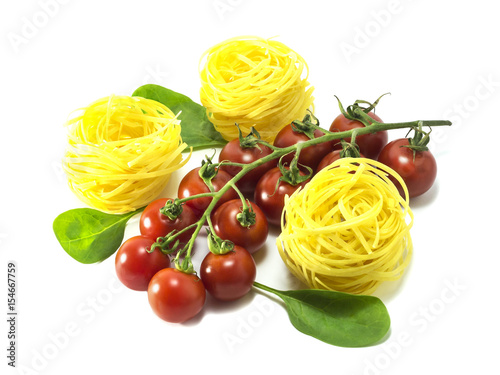Cherry tomatoes with dry Italian pasta on a white background.
