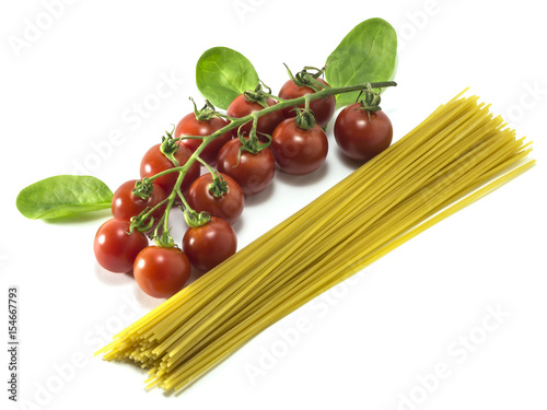 Cherry tomatoes with dry Italian pasta on a white background.