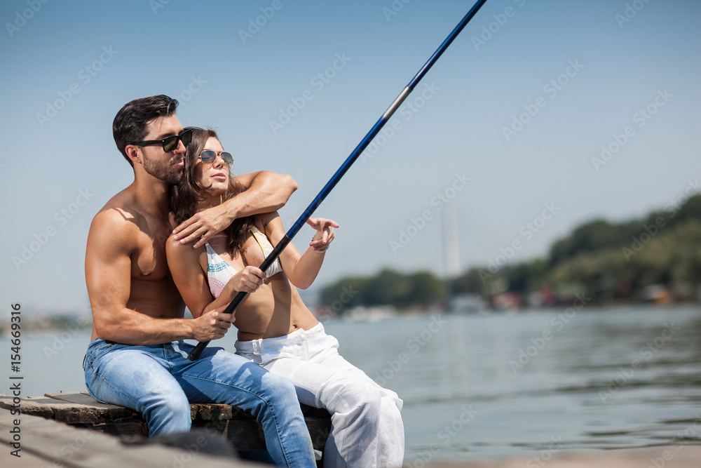young couple in love fishing on summer day