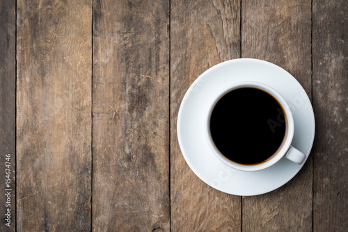 White coffee cup on an old wooden table. Close up