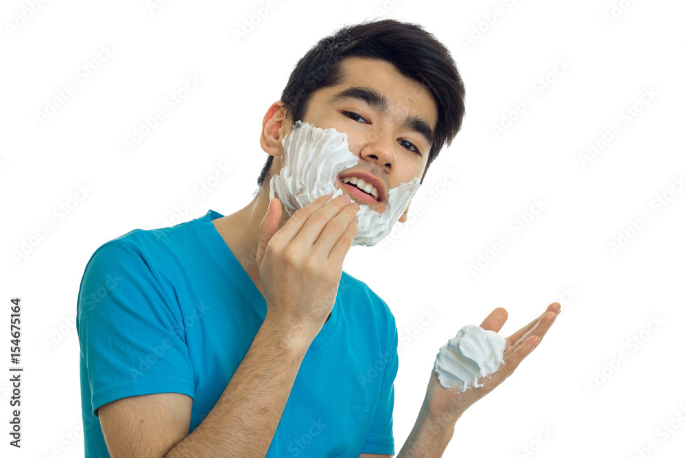 Portrait of joyous beautiful guy who is causing the foam to the beard looks into the camera and laughs Portrait of joyous beautiful guy who is causing the foam to the beard looks into the camera and laughs