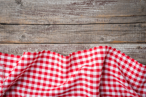 Red folded tablecloth on an old wooden table. Close up