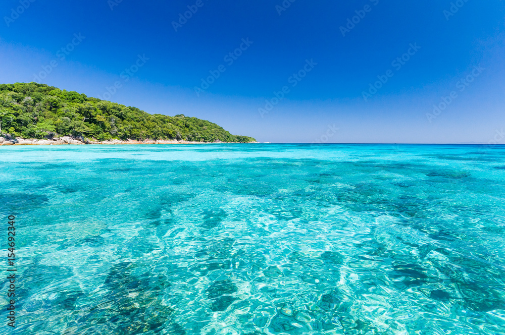 Beautiful sea with clear blue sky and island as background.