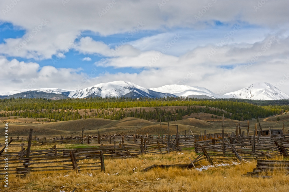 Abandoned Ranch Against Snow Covered Mountain Backdrop