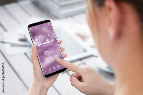 Woman use smart home control app on mobile phone. photo