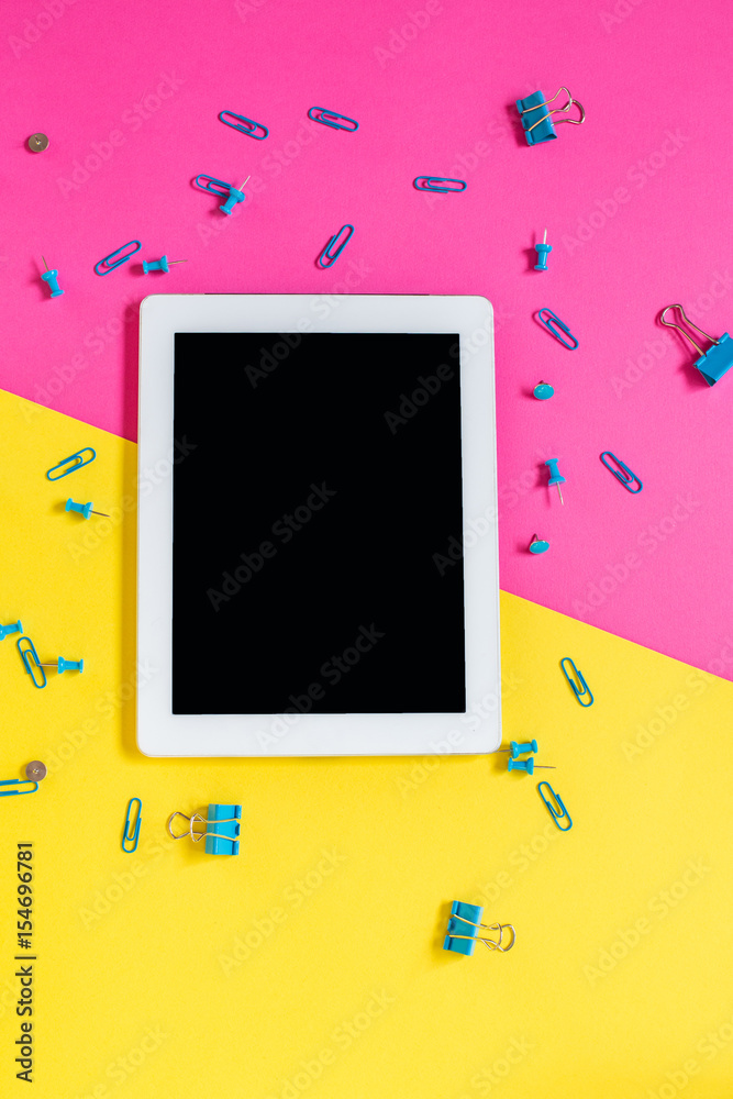 Stationery on a pink and yellow background. Paper clips and binders Stationery on a pink and yellow background. Paper clips and binders