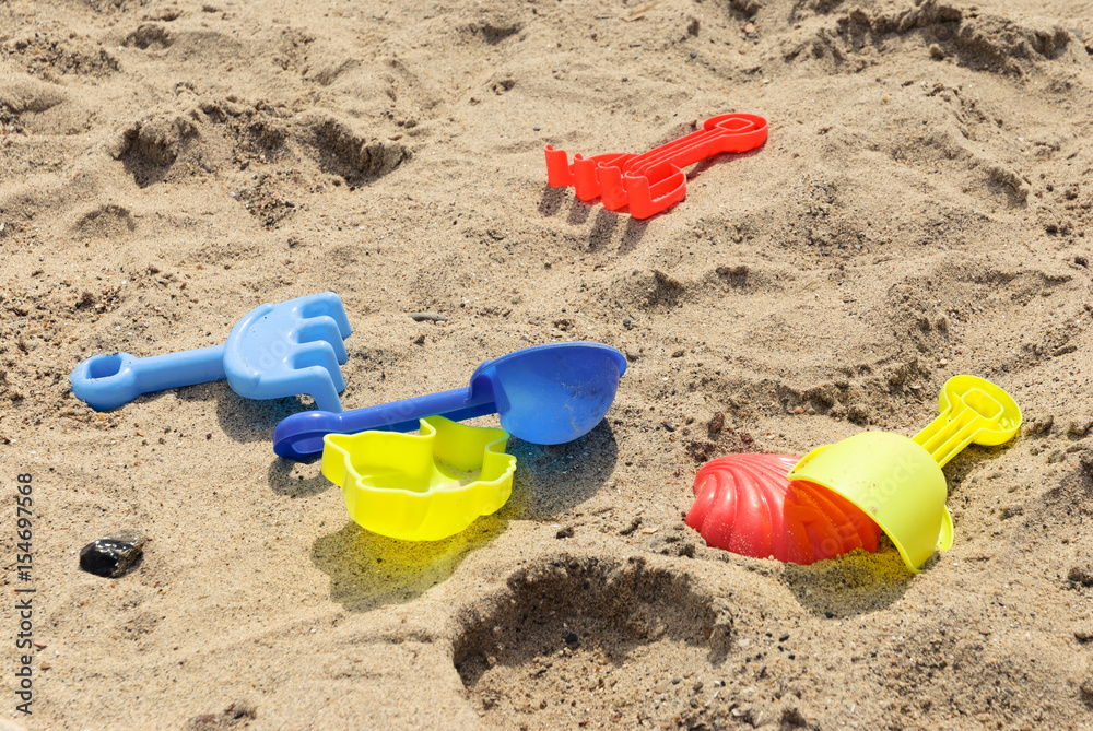 plastic toys on a sandy beach in summer plastic toys on a sandy beach in summer