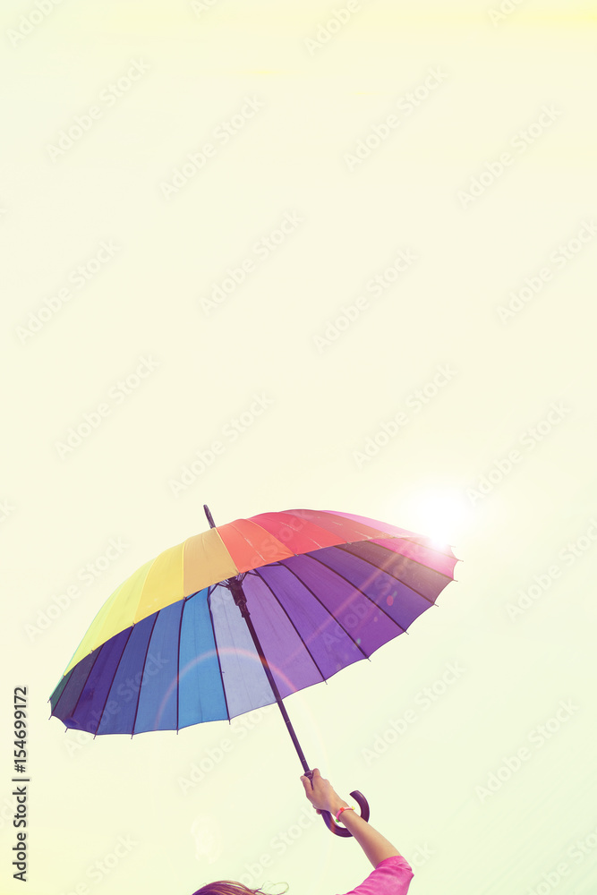 woman holding colorful umbrella on the beach in summer . Summer Vacation Concept. Filtered image processed vintage effect.