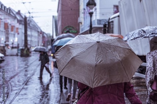 Fototapeta Naklejka Na Ścianę i Meble -  Menschen mit Regenschirmen in der Stadt